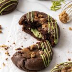 Close-up of a Dubai chocolate cookie broken open with creamy pistachio filling and chocolate chips